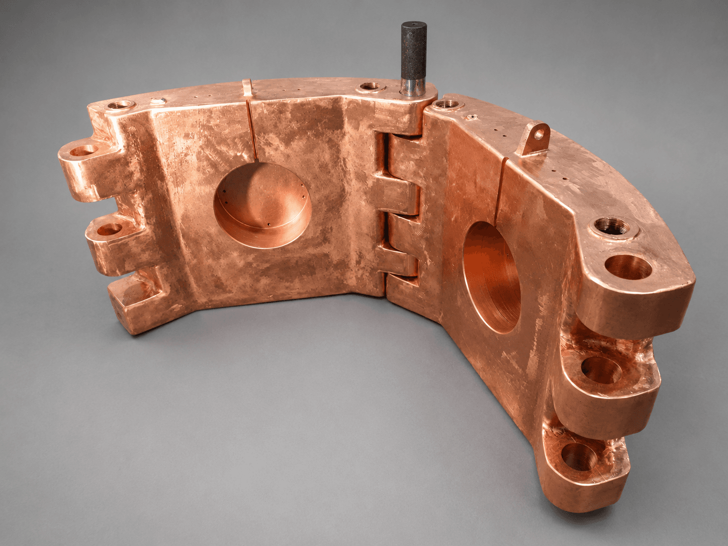 Open copper industrial component showing its geometry and mounting points